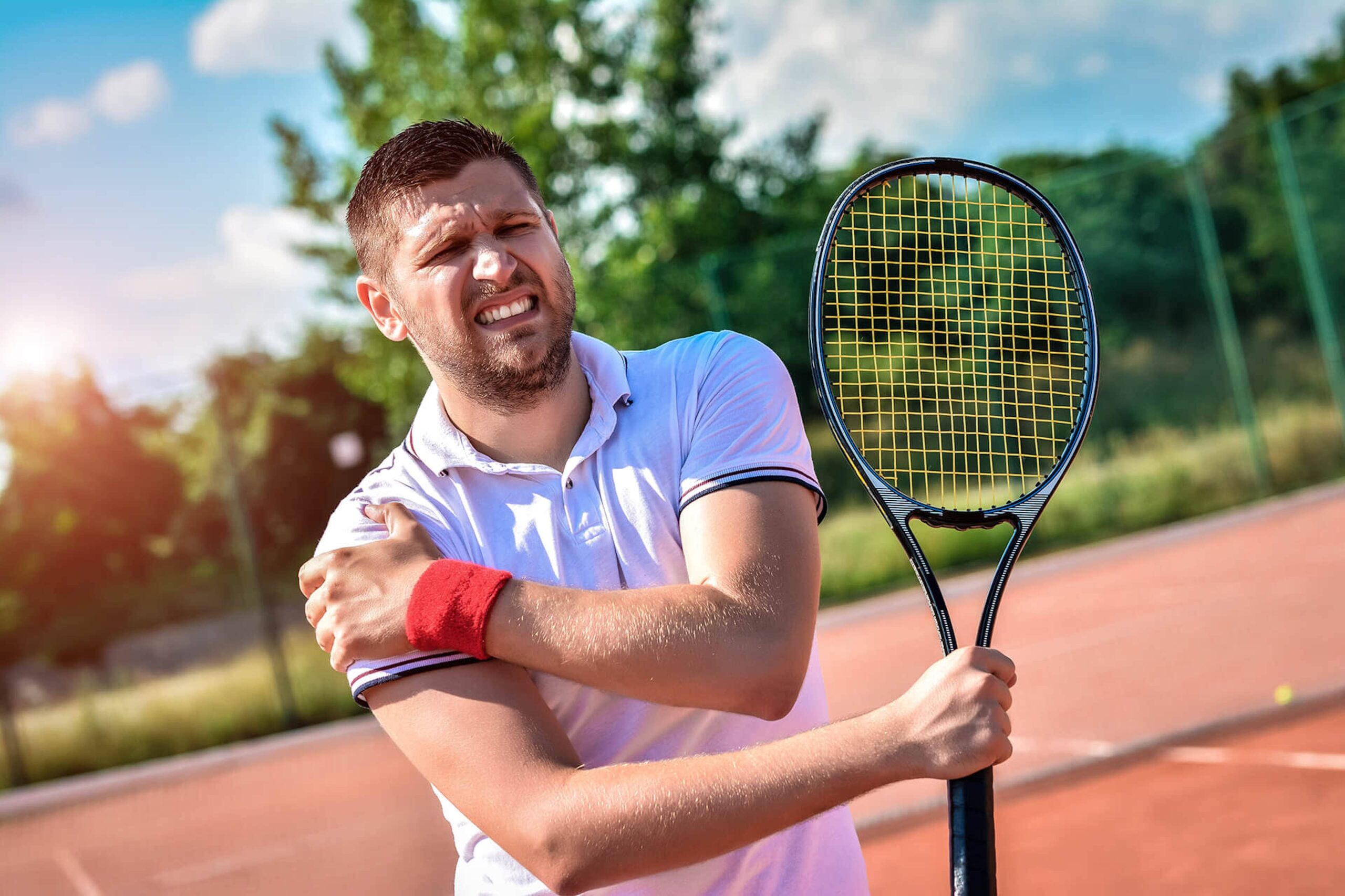 Man playing tennis clutches his shoulder. Shoulder dislocations and torn shoulder labrums are common injuries Dr. Goradia of G2 Orthopedics treats. Schedule your visit today!